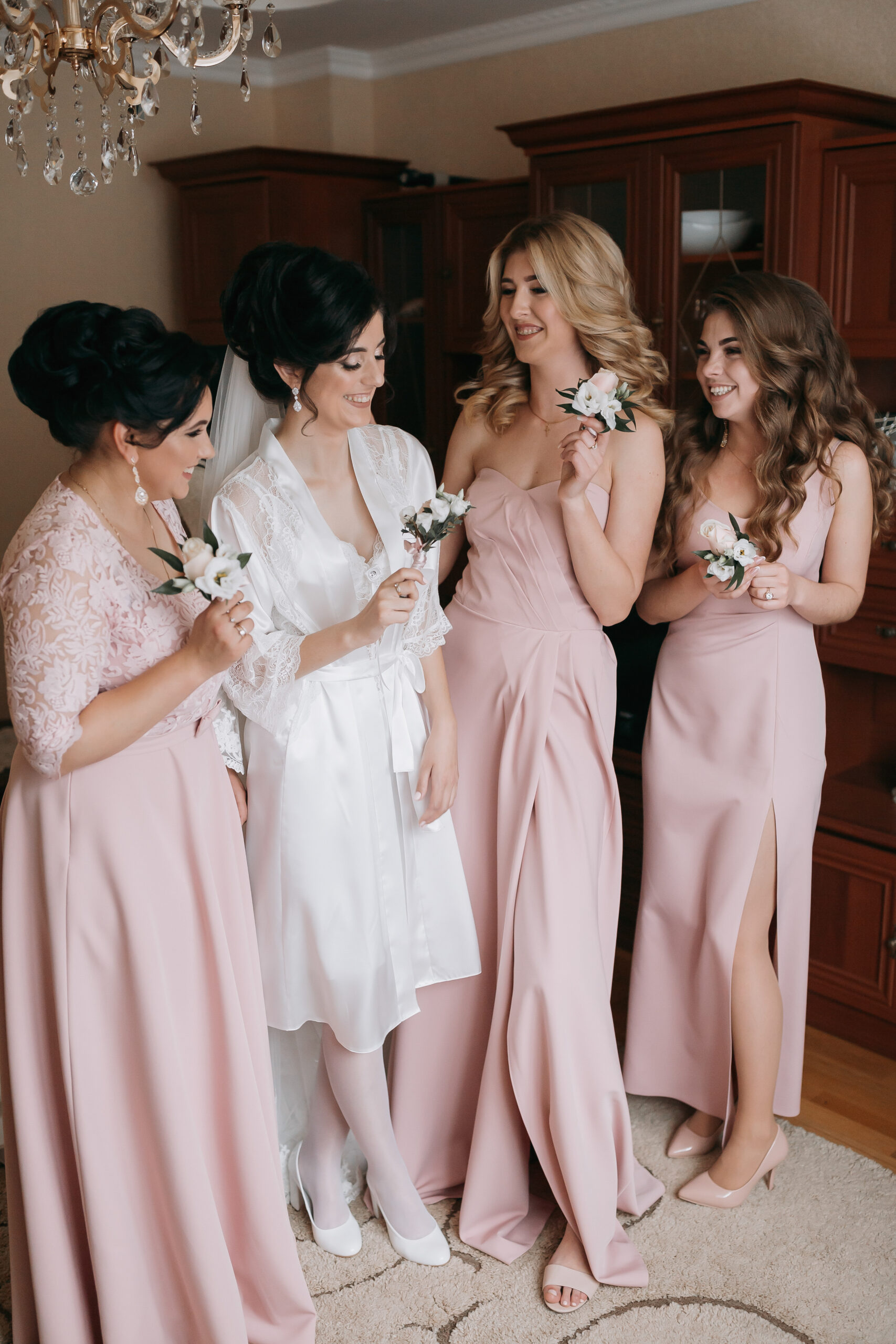 A group of women are posing for a picture, with one of them wearing a white gown
